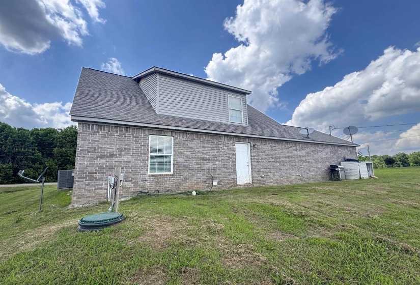 Brick exterior with a gray shingle roof, featuring a gable dormer with horizontal siding