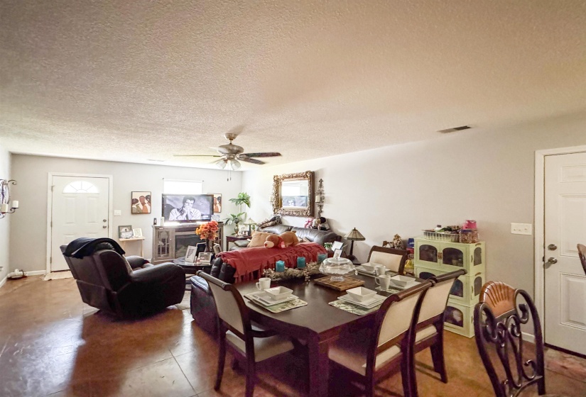 Open-concept living and dining area featuring wood-finish flooring