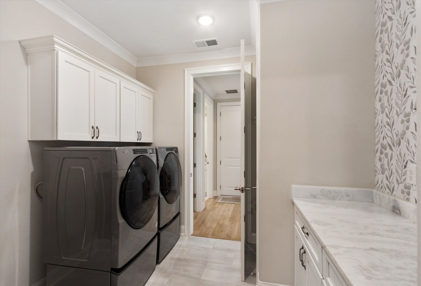 Laundry room featuring white shaker cabinetry, a white countertop, and light-toned flooring