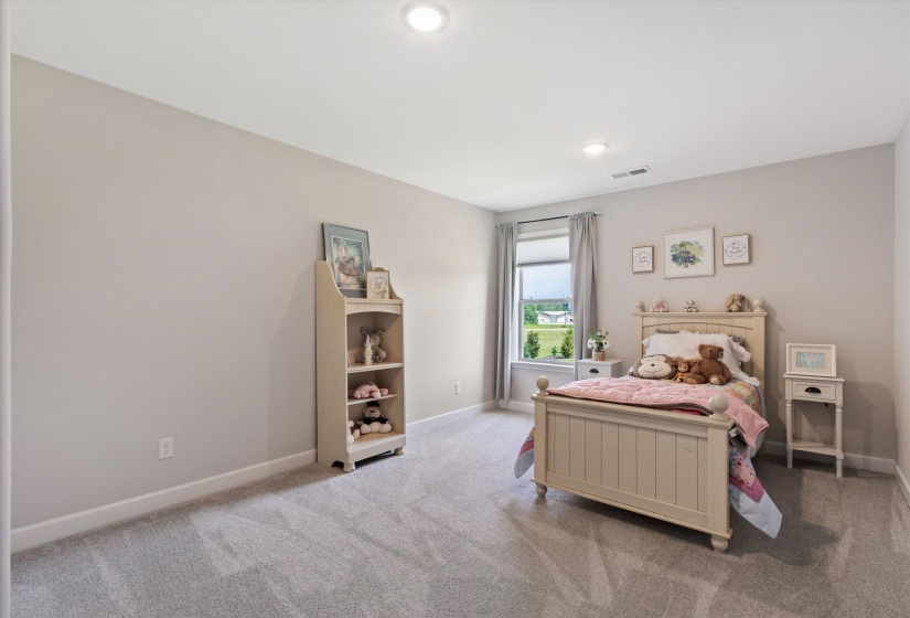 Carpeted room featuring a window with a roller shade, recessed lighting, and neutral wall tones