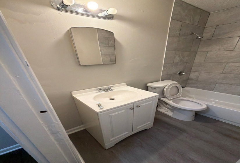 Bathroom featuring a white vanity with integrated sink, chrome faucet, and a wall-mounted medicine cabinet