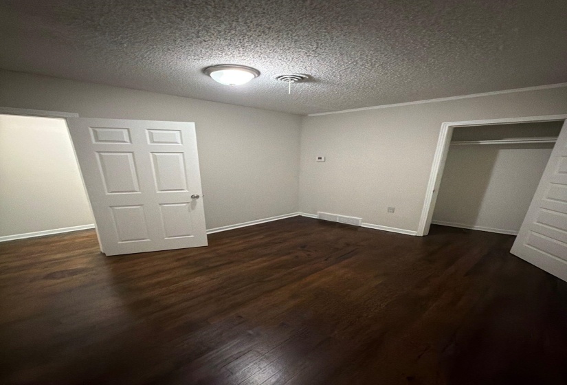 Interior room featuring dark wood-finish flooring and light-toned walls