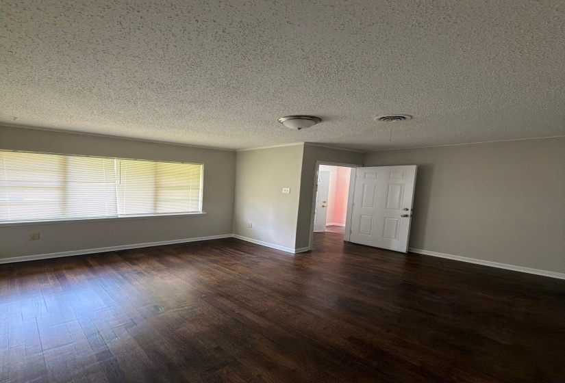 Living area featuring wood-finish flooring, light gray wall paint, and white baseboards