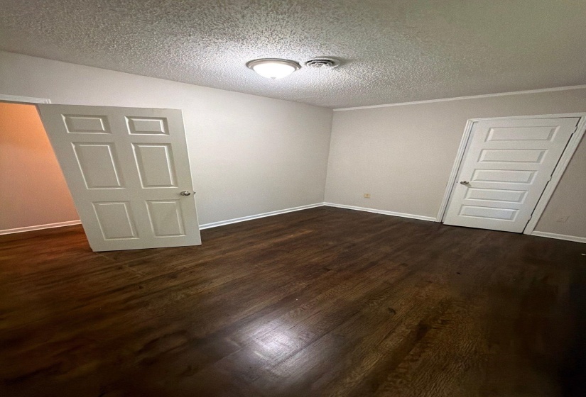 Interior room featuring wood-finish flooring, light grey walls, and white trim