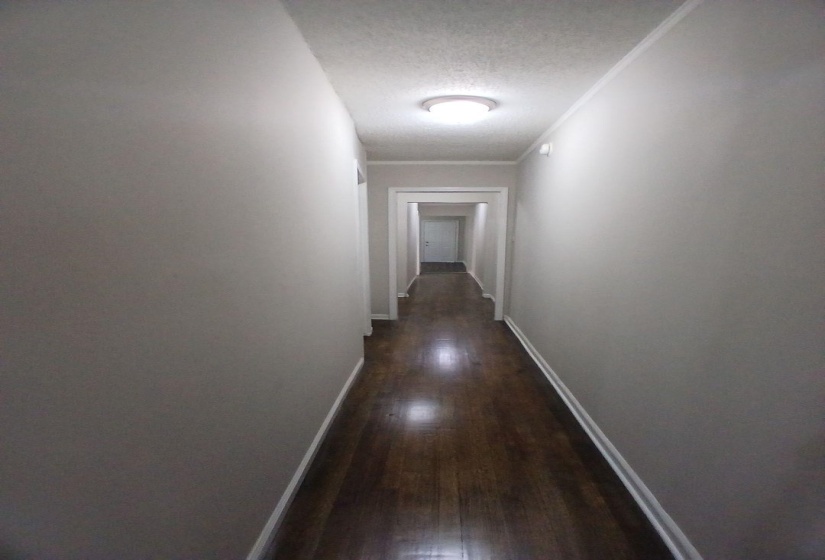 Hallway featuring wood-finish flooring and neutral wall tones