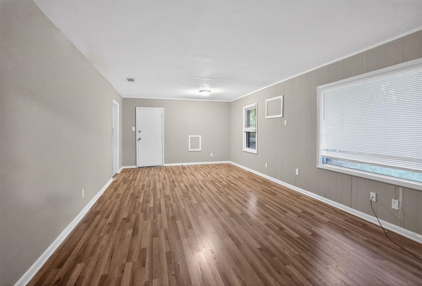 Spare room featuring dark wood-style floors and crown molding