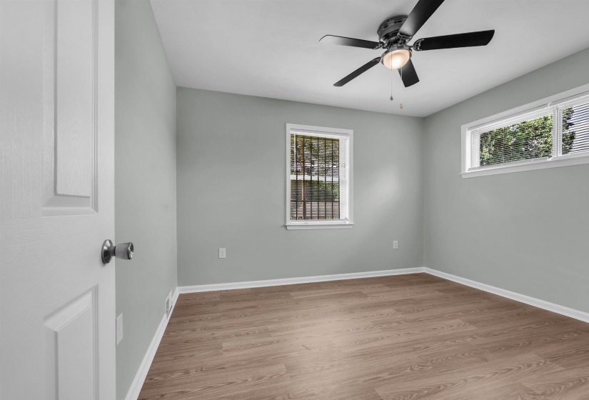 Interior room featuring wood-finish flooring, light gray walls, and white trim