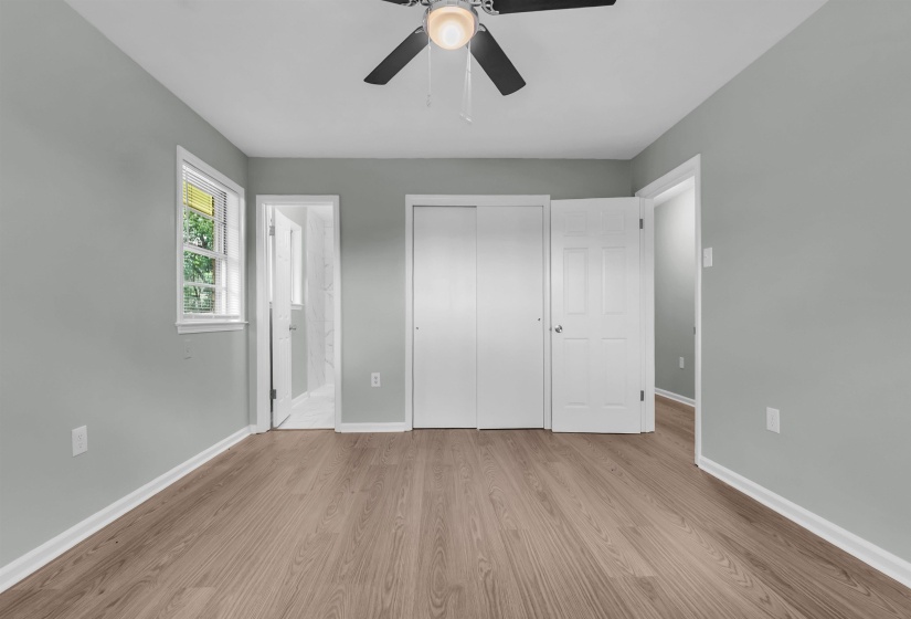 Room featuring light wood-finish flooring, light-toned walls, and a ceiling fan