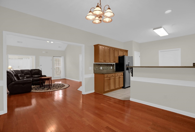 Expansive living area featuring wood-finish flooring, a vaulted ceiling, and an open concept layout