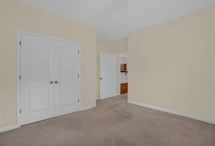 Neutral-toned room featuring carpet flooring, painted walls, white baseboards, and two paneled interior doors