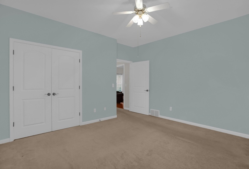 Interior space featuring light blue walls, a ceiling fan with integrated lighting, and neutral-toned carpeting