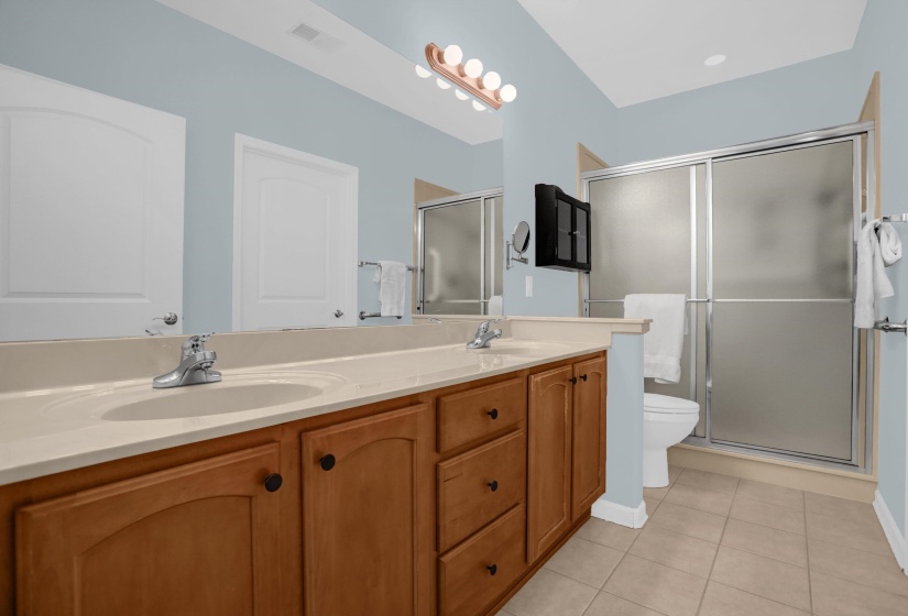 Bathroom featuring a double vanity with wood cabinetry and light-toned countertops