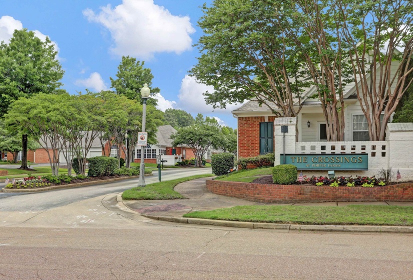 Entryway featuring a brick-faced sign with 