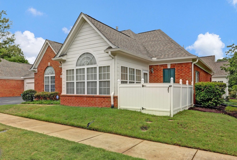 Brick and siding exterior featuring gabled roofs and arched transom windows