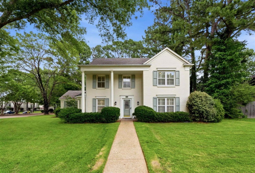 Traditional two-story exterior with a cream facade and a gray shingled roof