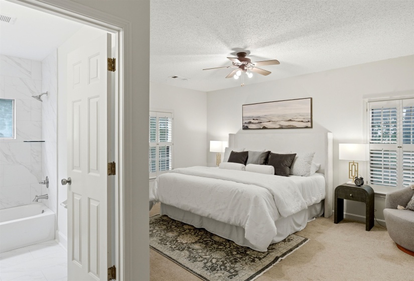 Spacious bedroom with carpet flooring and ceiling fan