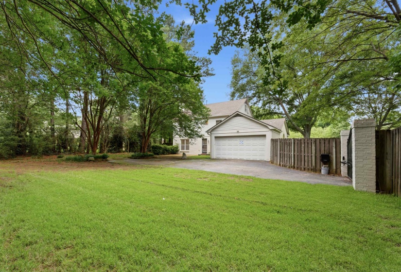 Spacious front yard with mature trees and established landscaping
