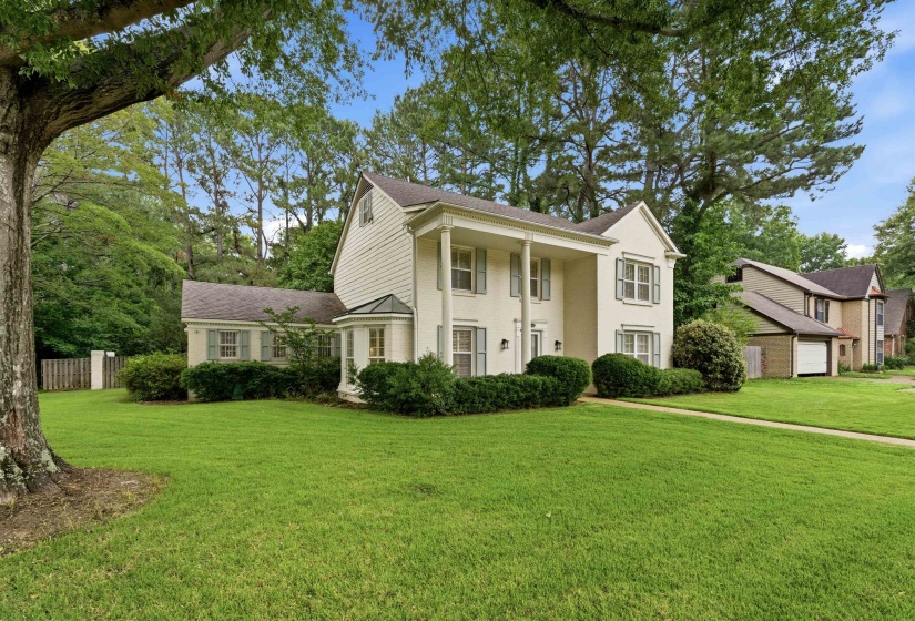Traditional two-story residence featuring a portico entry with columns