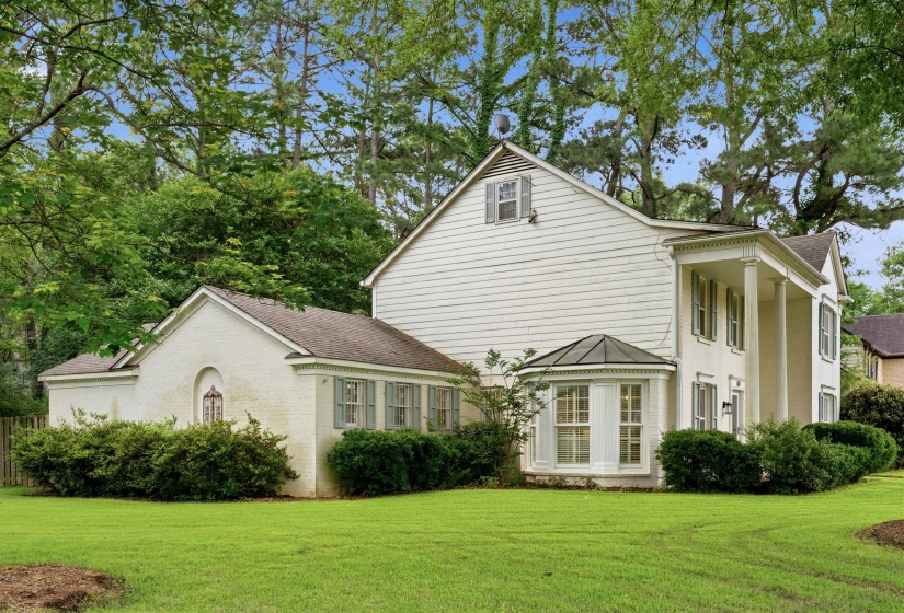 Traditional two-story residence featuring white siding and brick accents