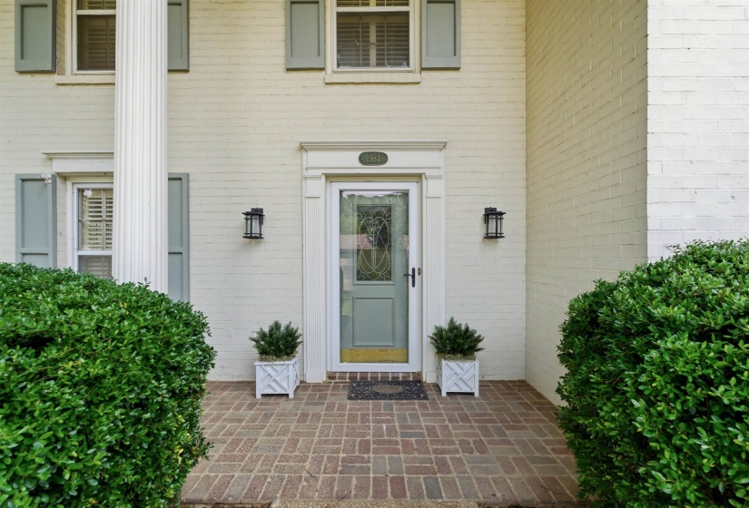Painted brick exterior with a prominent fluted column and light blue shutters