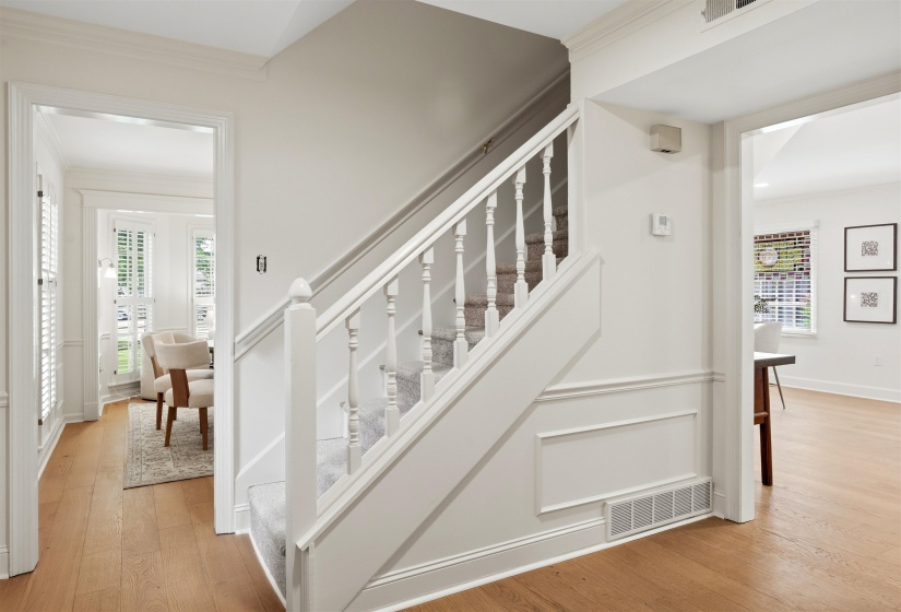 Staircase with white balusters and carpeted treads