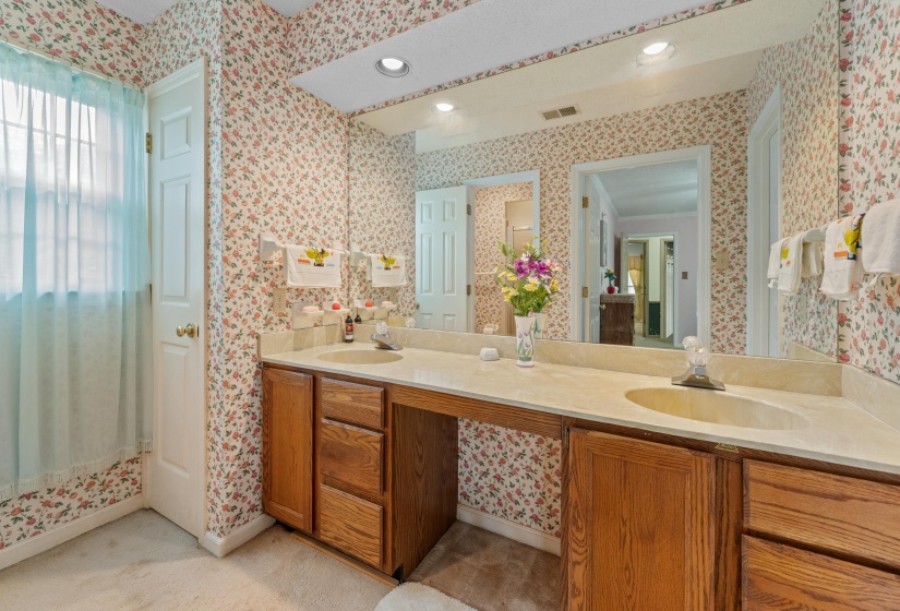 Double vanity with integrated sinks, light-toned countertop, and wood cabinetry