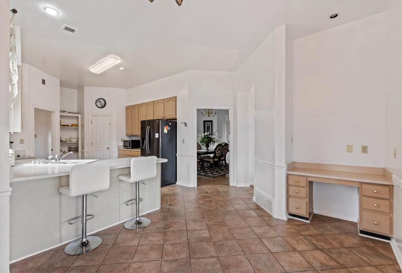Kitchen featuring black fridge, light countertops, a breakfast bar area, a peninsula, and stainless steel microwave
