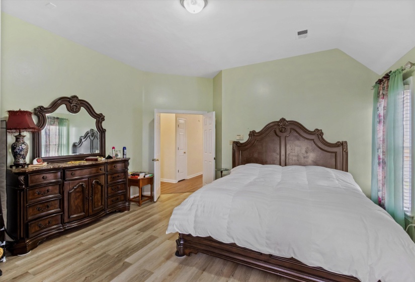 Bedroom featuring light wood-type flooring and vaulted ceiling