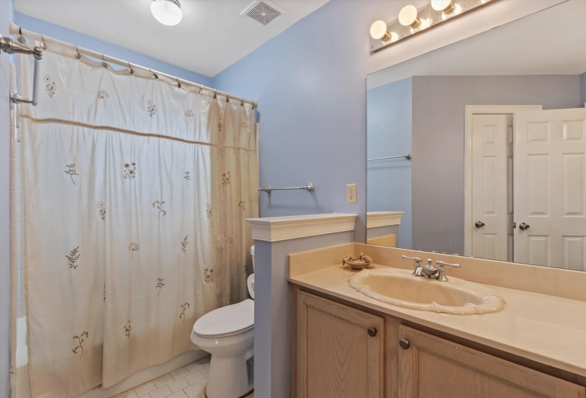 Bathroom featuring curtained shower, vanity, and light tile patterned floors