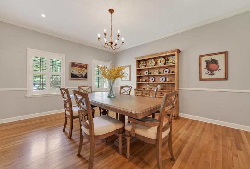 Dining area featuring hardwood flooring, white baseboards, and a chair rail molding