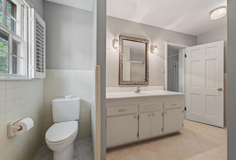 Bathroom featuring a white vanity with integrated sink, panel cabinetry, and an ornate framed mirror
