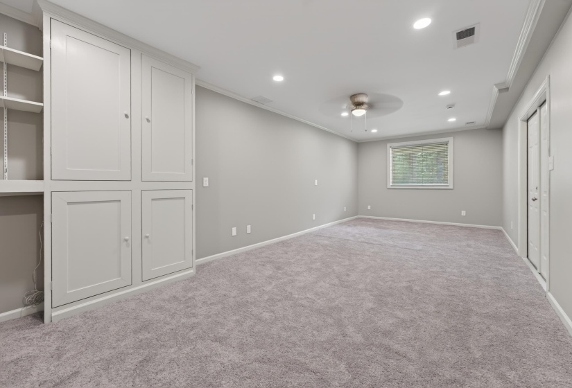 Spacious room with built-in cabinetry, recessed lighting, and a ceiling fan