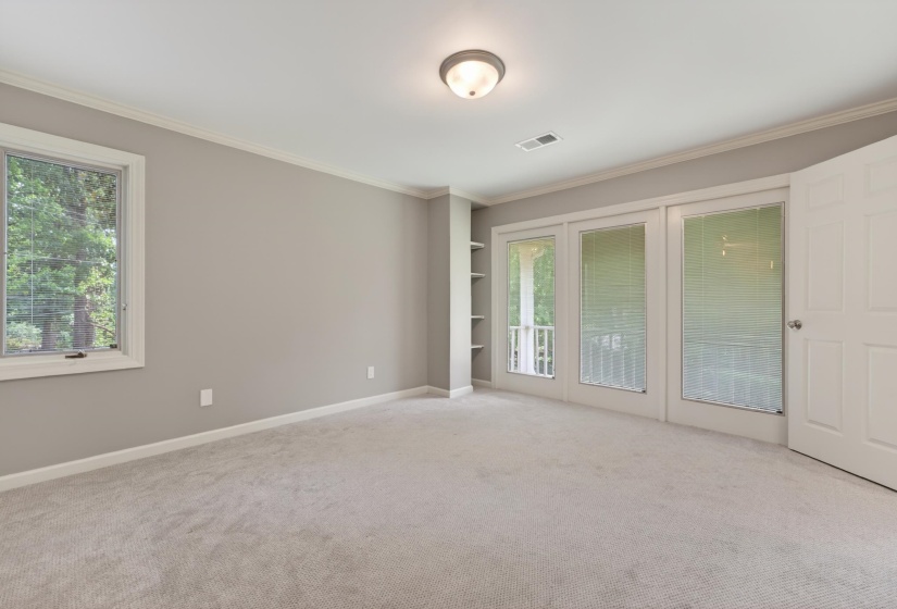 Carpeted room with neutral wall tones and crown molding