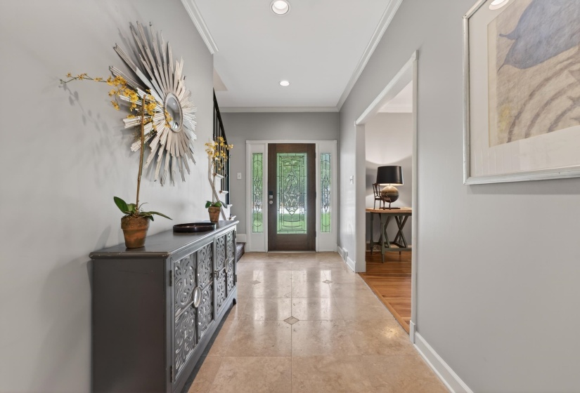 Foyer entry with polished tile flooring, crown molding, and recessed lighting