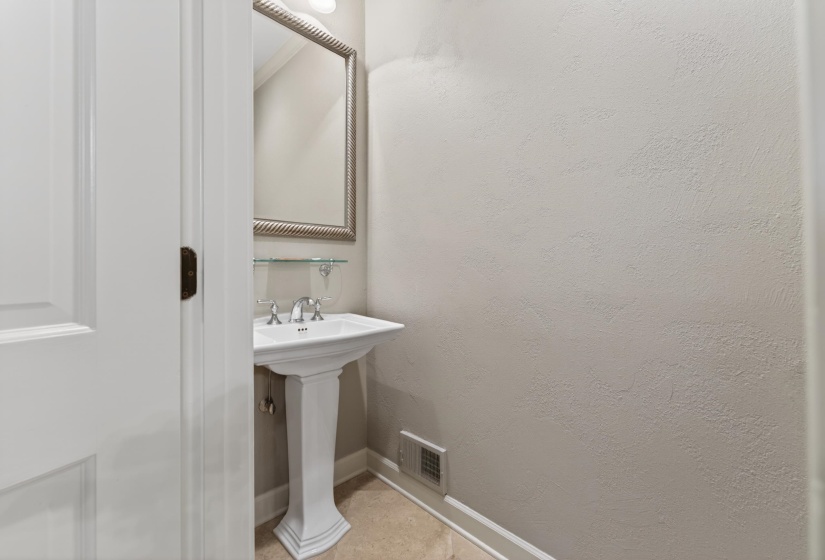 Pedestal sink with chrome faucet, framed mirror, and glass shelf