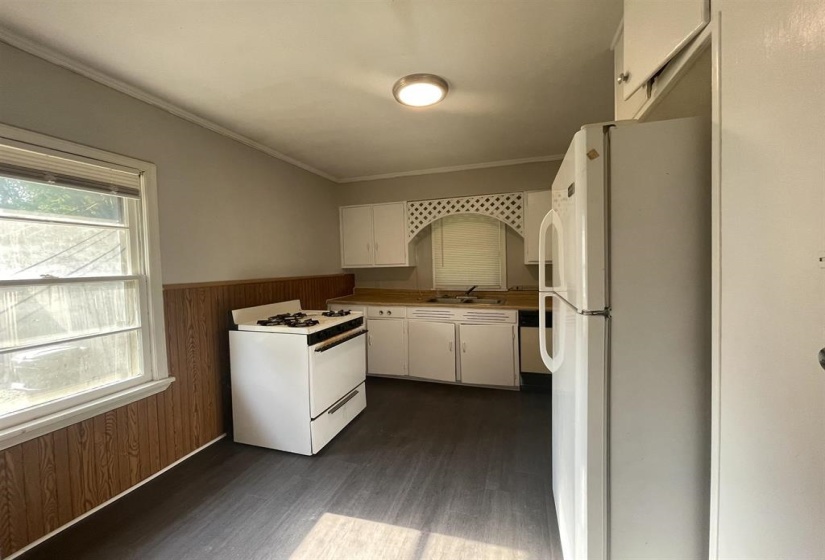 Kitchen featuring white cabinetry, a built-in white gas range, and wood-finish flooring
