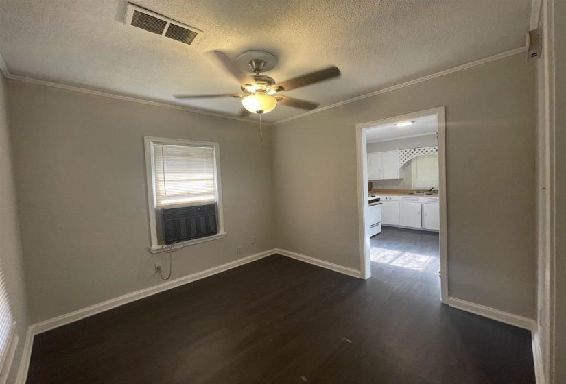 Interior room featuring wood-finish flooring, light neutral wall paint, and white baseboards