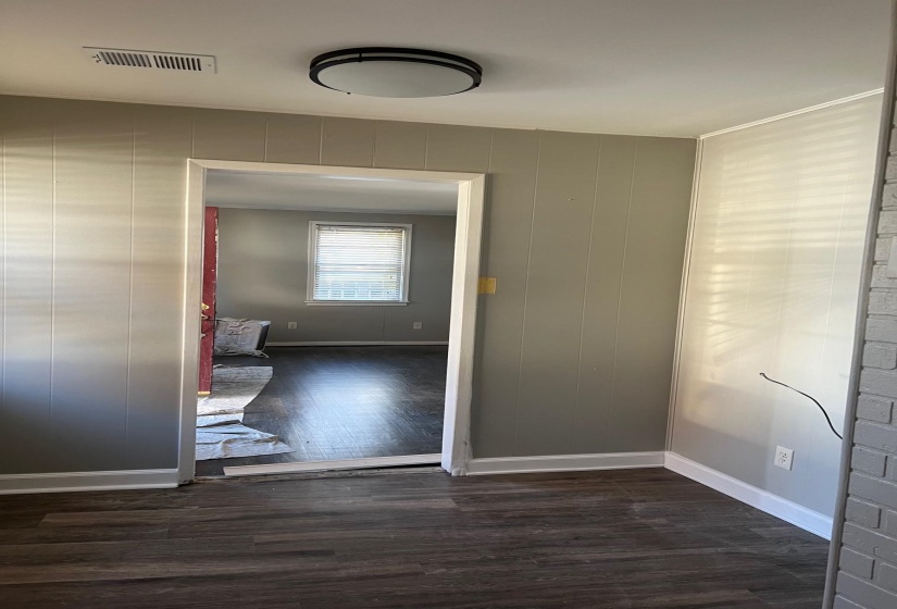 Unfurnished room featuring wood finished floors, visible vents, and baseboards