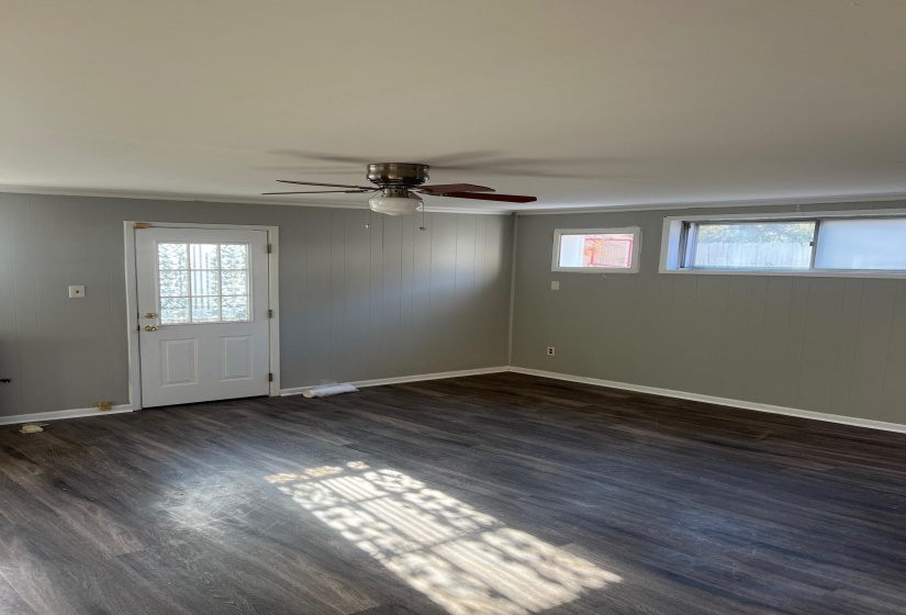 Interior space featuring baseboards, a wealth of natural light, dark wood-type flooring, and ceiling fan