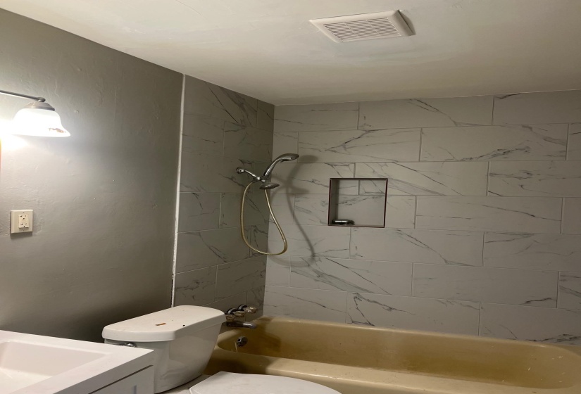 Full bathroom with shower / bathing tub combination, visible vents, toilet, and vanity