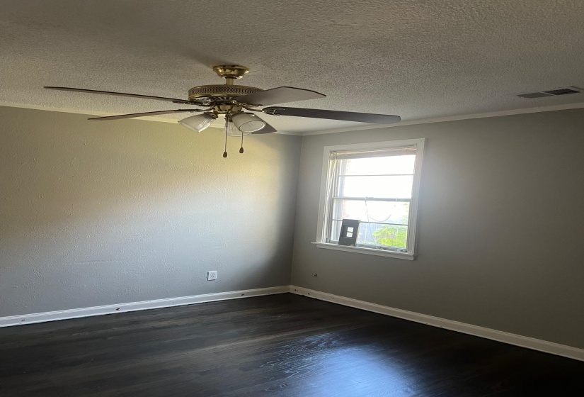 Spare room with visible vents, dark wood-type flooring, baseboards, a textured ceiling, and ceiling fan