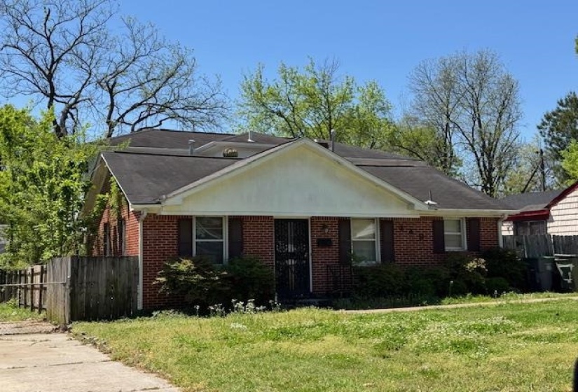 Bungalow-style home featuring a front yard, brick siding, and fence
