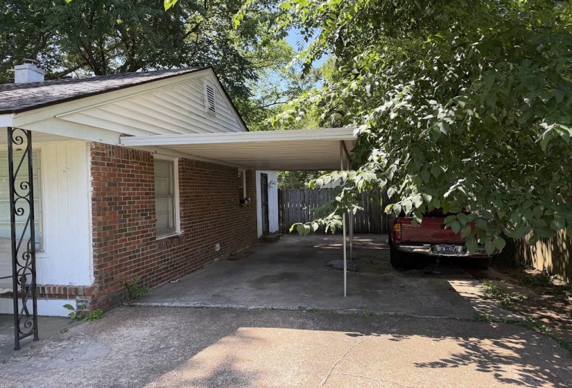 Brick exterior with white siding accents and a carport