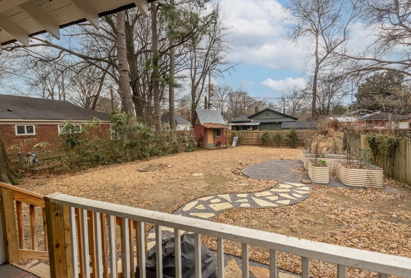 Fenced backyard featuring a shed