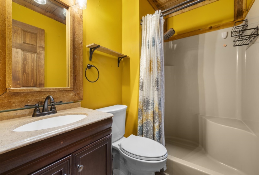 Bathroom featuring a dark wood-finish vanity with an integrated sink, a light-colored countertop, and an oil-rubbed bronze faucet