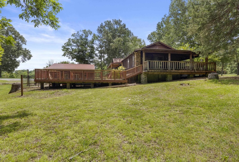Expansive rear deck featuring wood railings, a covered porch section, and a separate open-air deck area