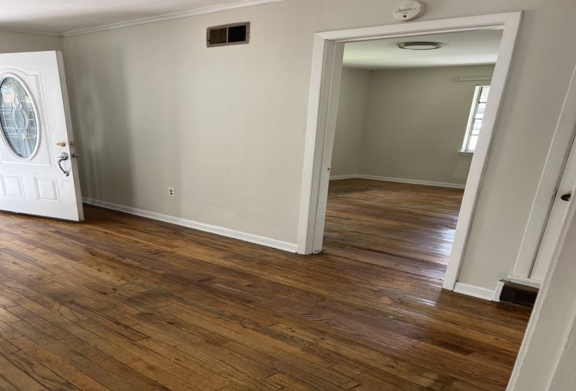 Hardwood flooring extends throughout the space, complemented by neutral wall tones and white trim