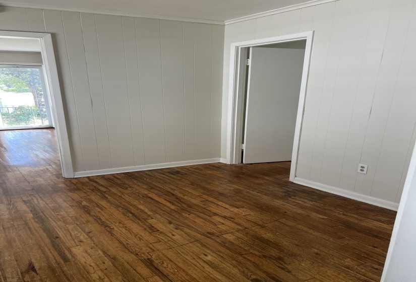 Hardwood-look flooring throughout, complemented by vertical paneling on walls