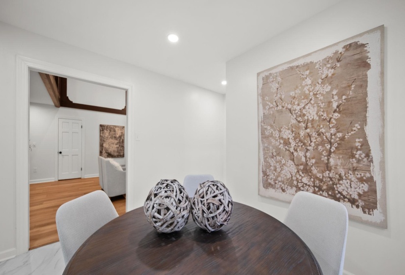 Dining area featuring a wood-finish round table and light-colored chairs