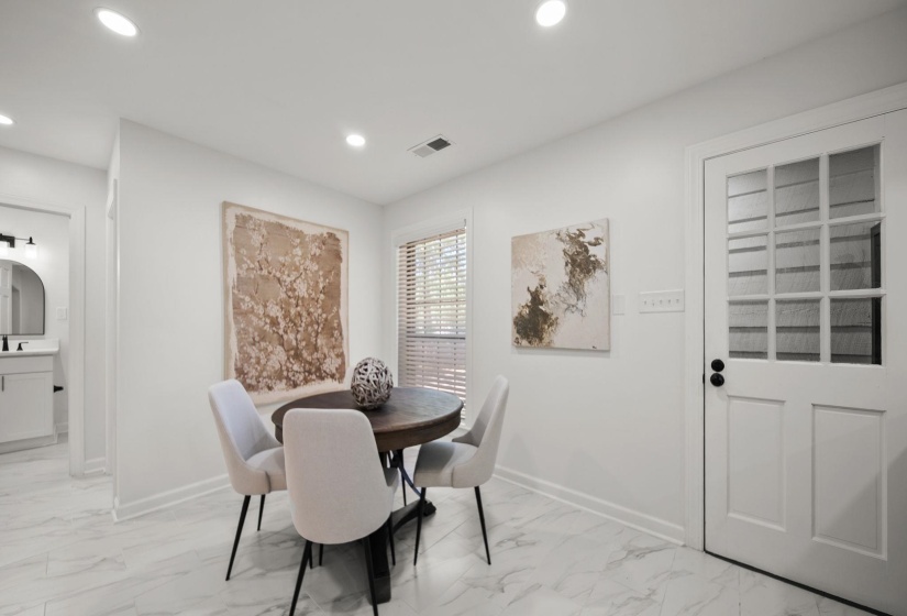 Dining area featuring recessed lighting, large window with blinds, white trim, and white paneled door with glass inserts